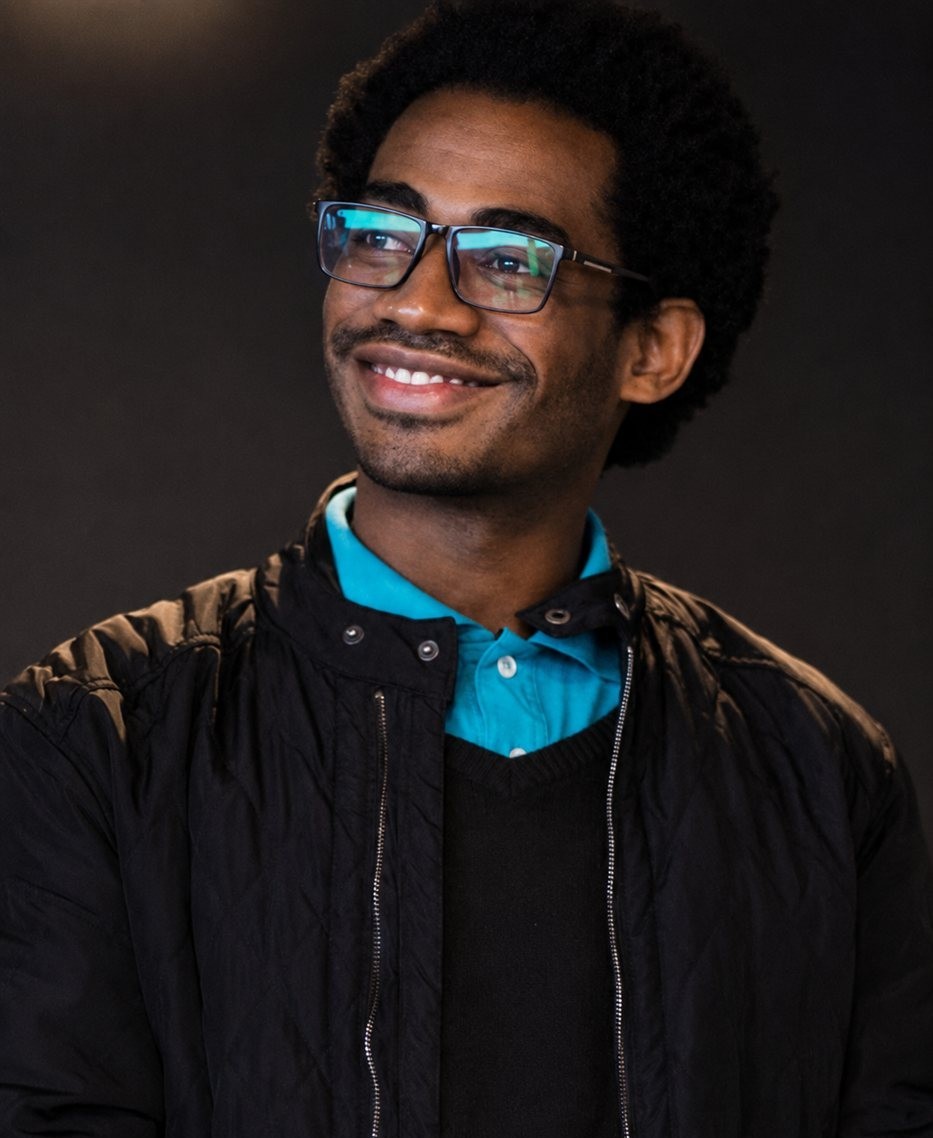 Vinícius Vilella, psicólogo, sorrindo em um ambiente acolhedor
